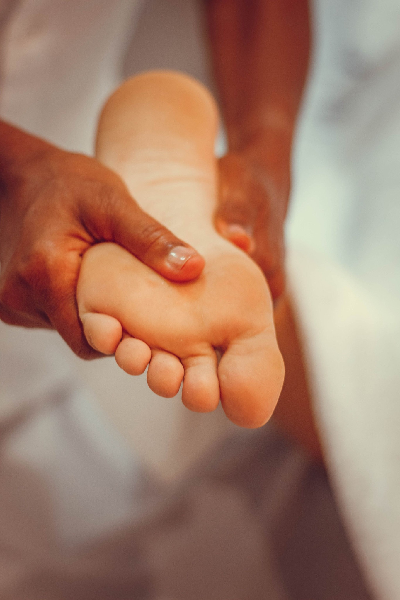 Hands assessing the sole of a foot